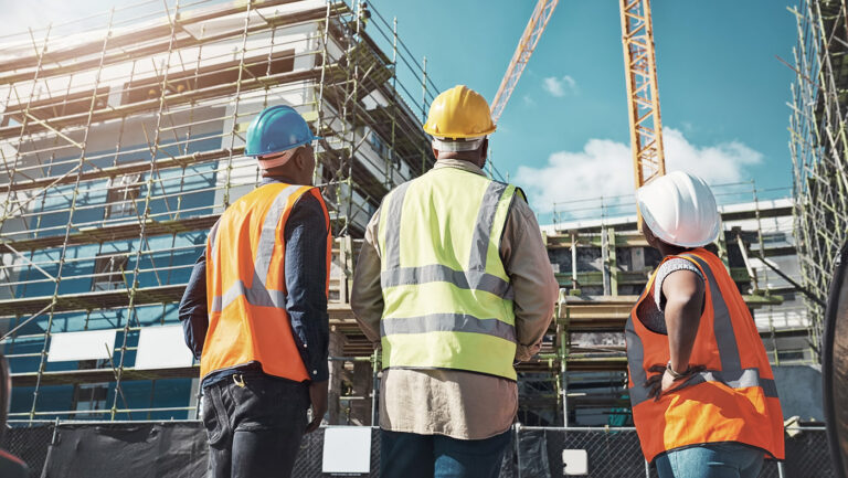 3 inzynierów oglada plac budowy